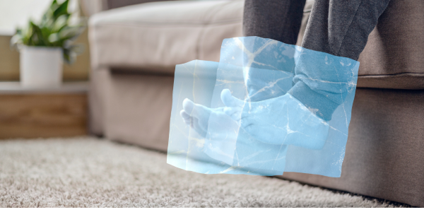 Person med kolde fødder der får varme af bambusstrømper fra BambooNordic